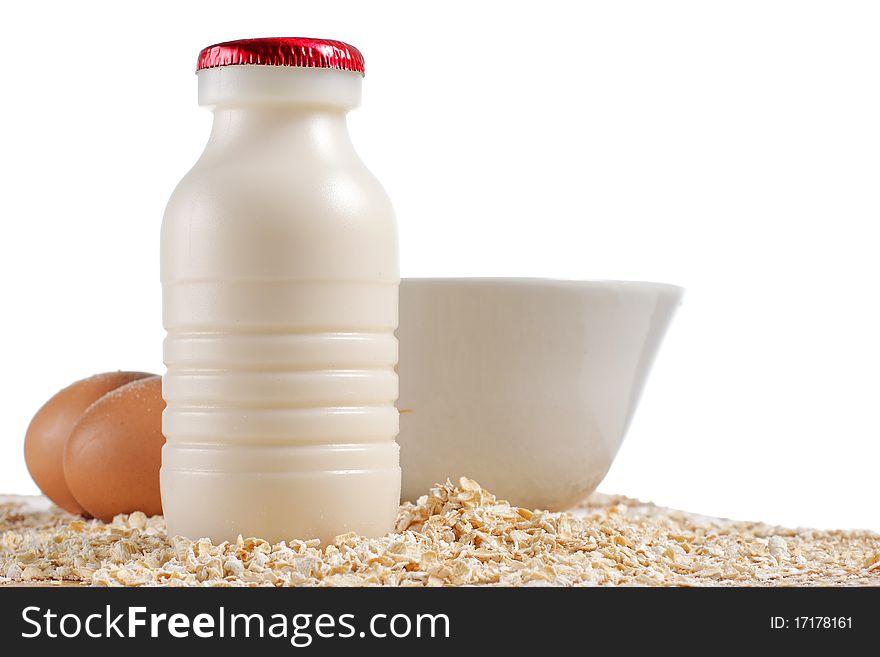 A bottle of milk, eggs and oatmeal on the table. A bottle of milk, eggs and oatmeal on the table
