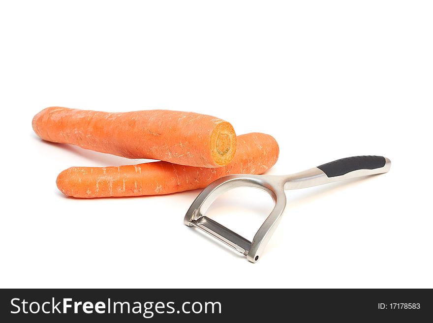 A carrot peeler and carrots isolated on a white background. A carrot peeler and carrots isolated on a white background.