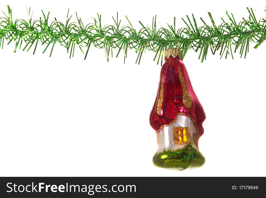 Christmas decoration house glass toy over green tinsel isolated over white background