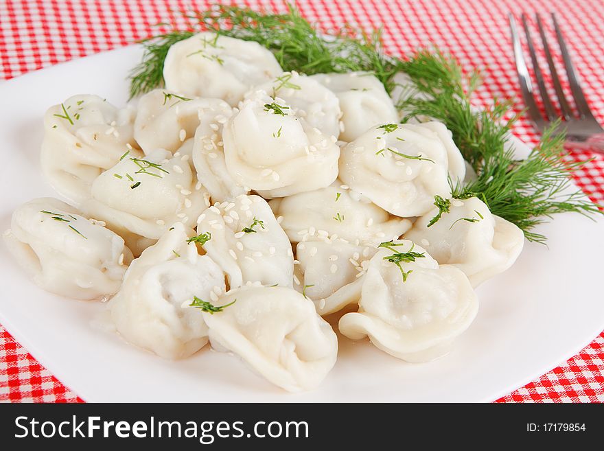Boiled dumplings on a plate on a red tablecloth