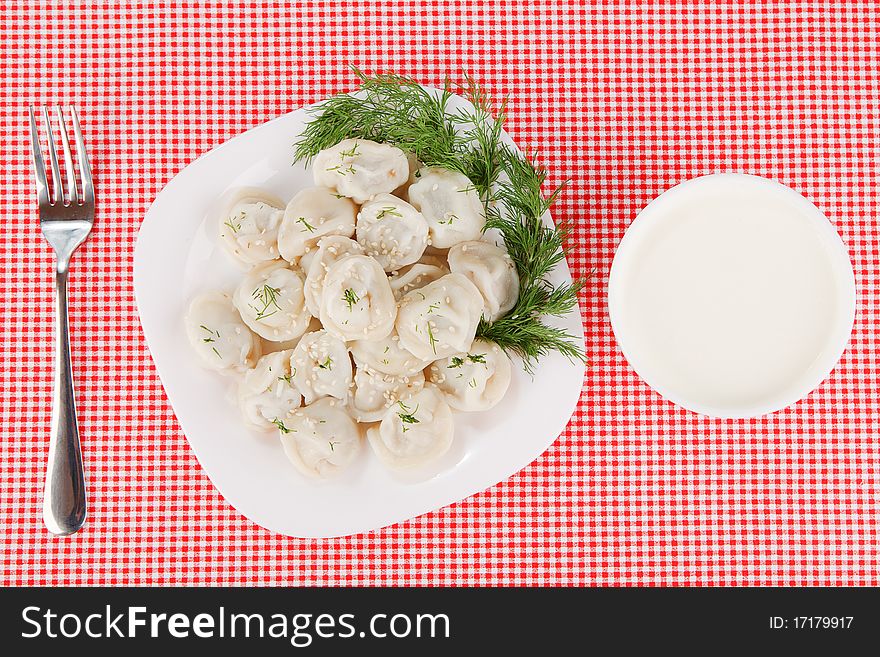 Boiled dumplings on a plate on a red tablecloth