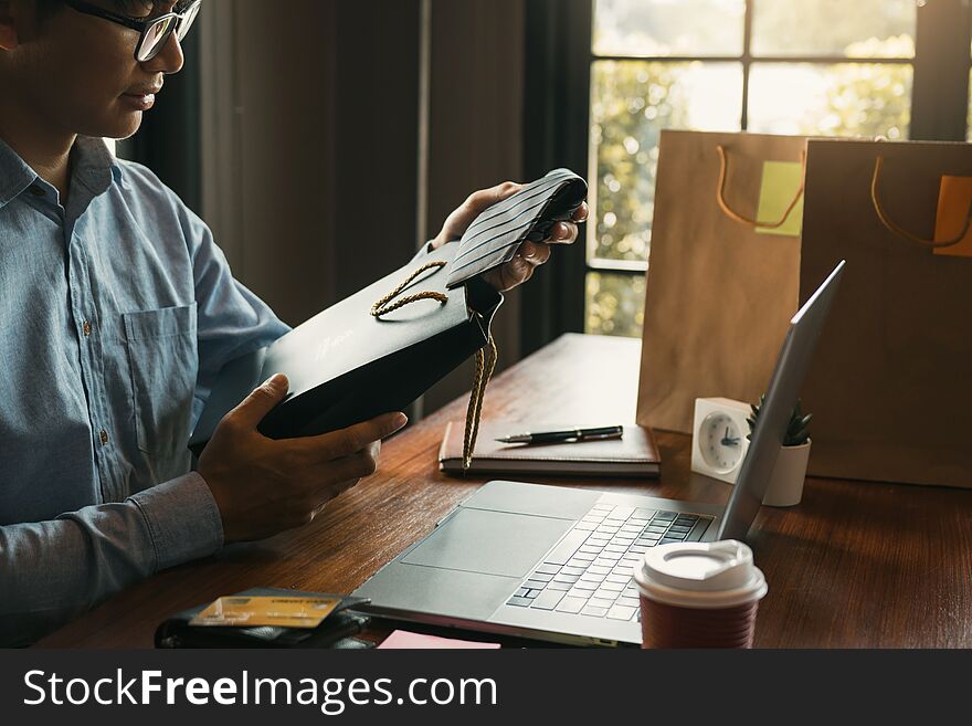 Man holding a gift bag with a necktie inside out as a gift at the cafe