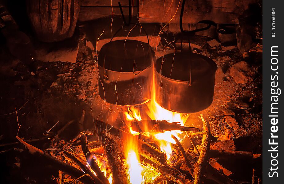 Two tourist bowls over campfire at night. Two tourist bowls over campfire at night