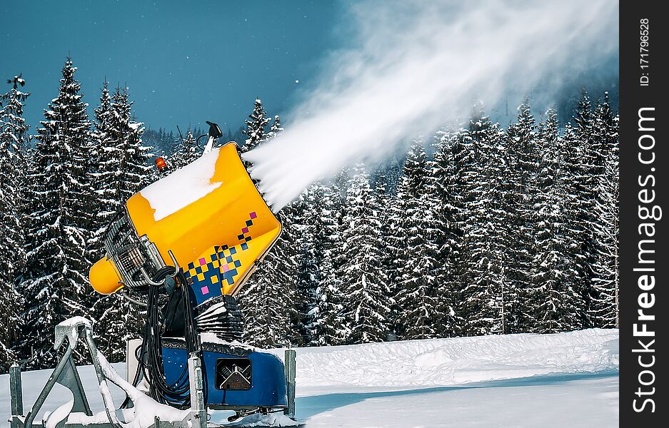 Professional artificial snow machine cannon making snowflakes from water at ski resort. Professional artificial snow machine cannon making snowflakes from water at ski resort