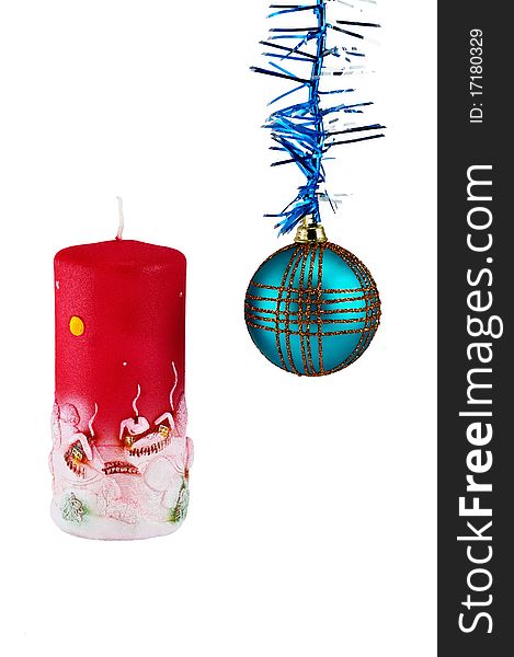 Decorative christmas candle of red color with the image of rural small houses and christmas ball ornament. Isolated on white. Decorative christmas candle of red color with the image of rural small houses and christmas ball ornament. Isolated on white.