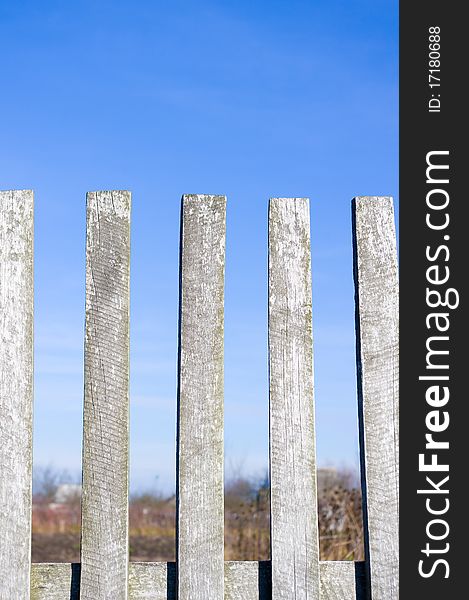 A grapesteak fence in green grass under a blue sky. A grapesteak fence in green grass under a blue sky.