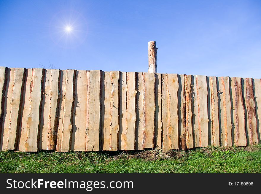 A grapesteak fence in green grass under a blue sky. A grapesteak fence in green grass under a blue sky.