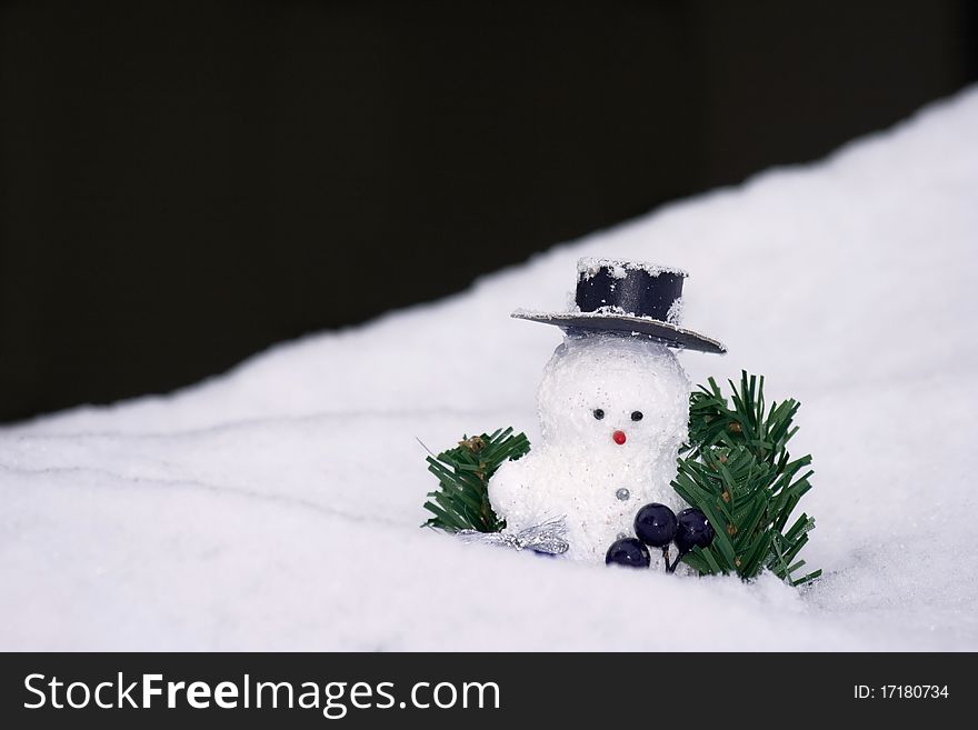 Snowman with a small christmas-tree branch with black background. Snowman with a small christmas-tree branch with black background