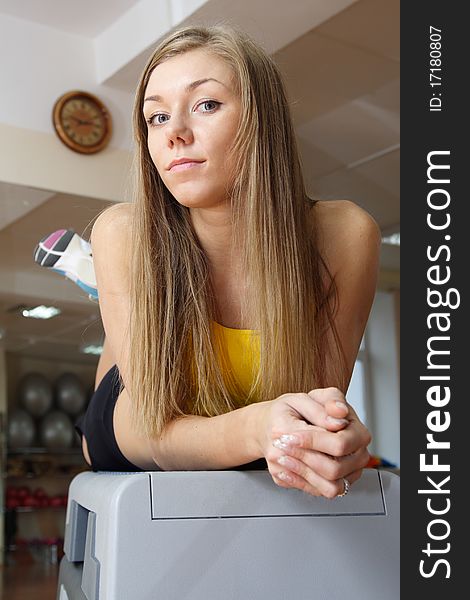 Beautiful Blonde girl sitting on steps in gym