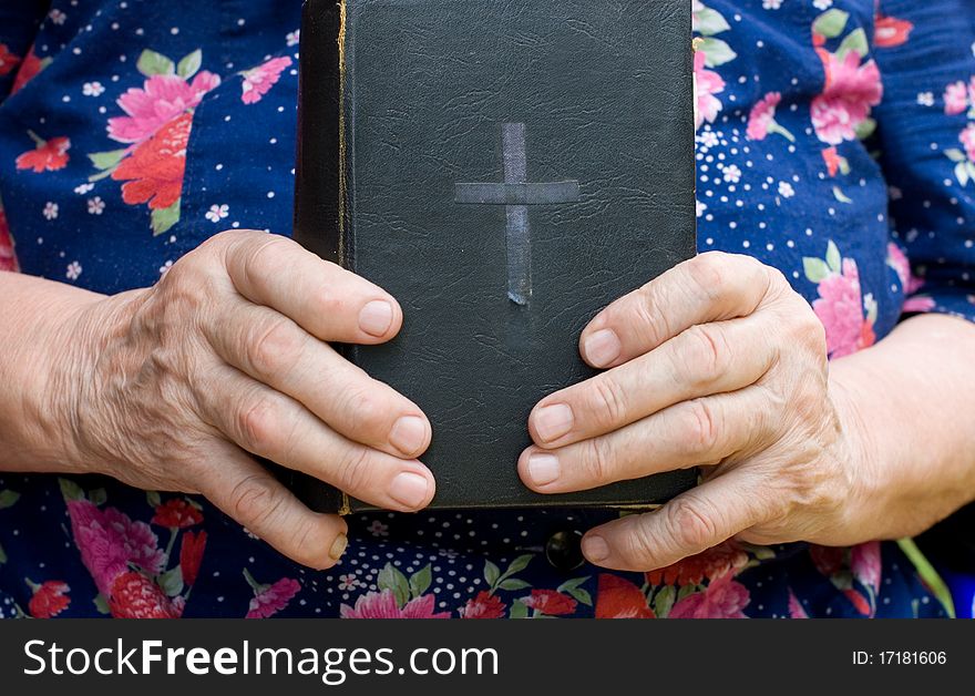 The old woman reads the bible close up