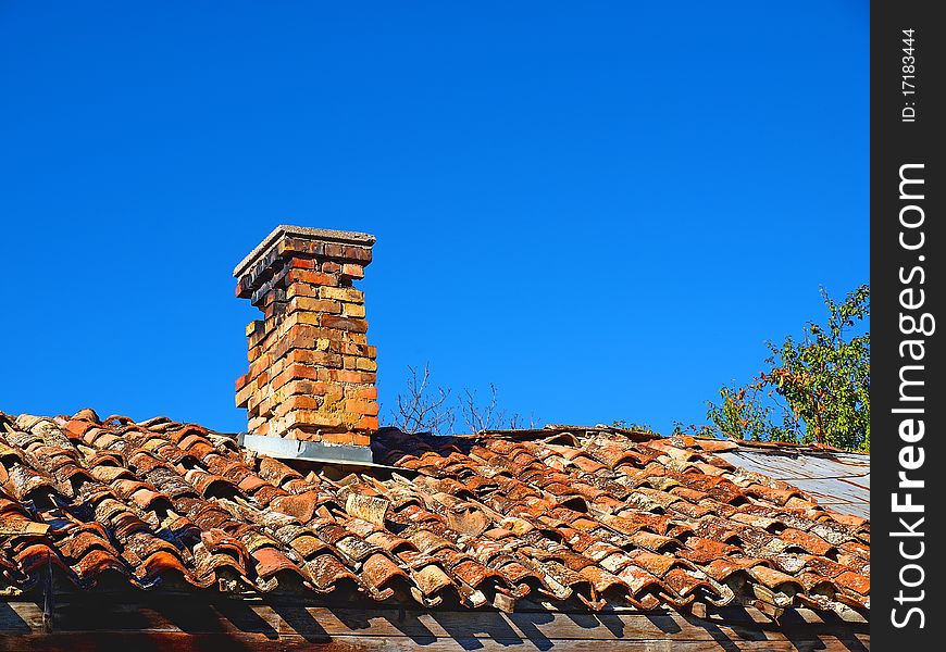 Old tiled roof with a small chimney