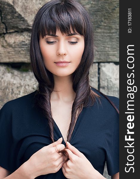 Young beautiful girl the brunette, holds hair