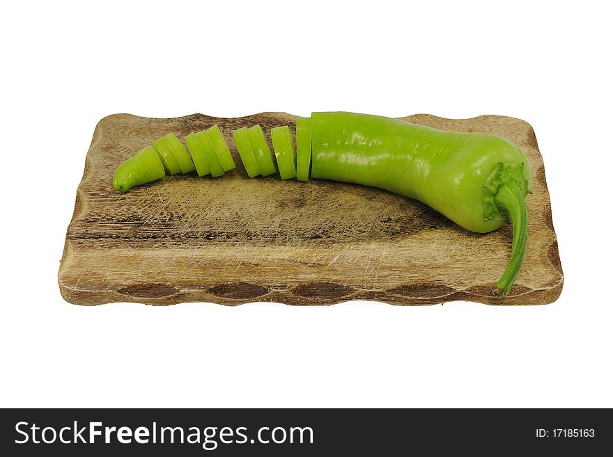 Green pepper on a wooden cutting board isolated on wihte background