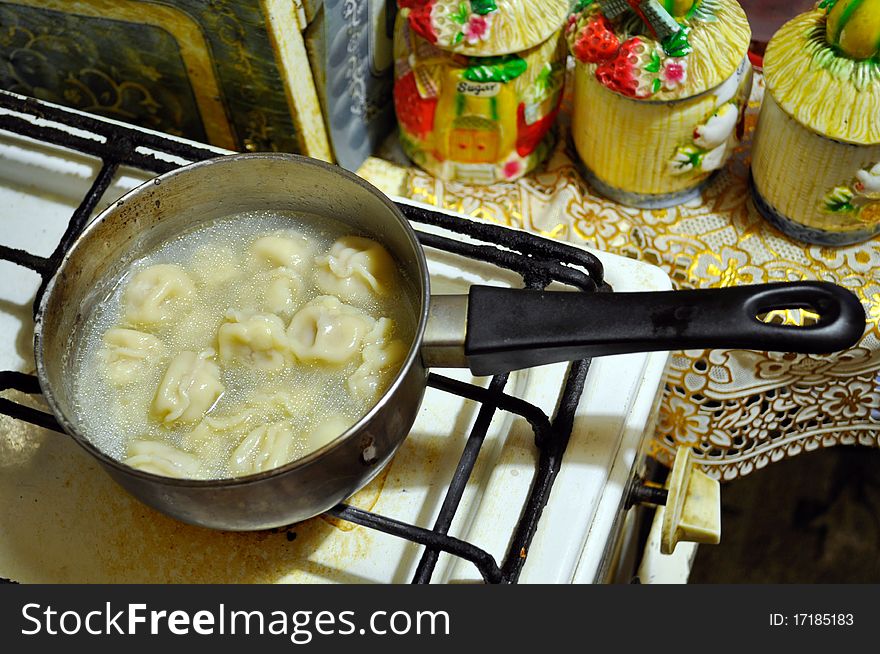 Dumplings cooked in a ladle-drenched juicy soup on a gas cooker. Dumplings cooked in a ladle-drenched juicy soup on a gas cooker