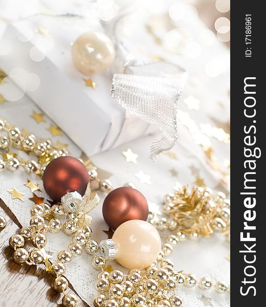 Christmas gift and baubles on defocused lights background. Christmas gift and baubles on defocused lights background