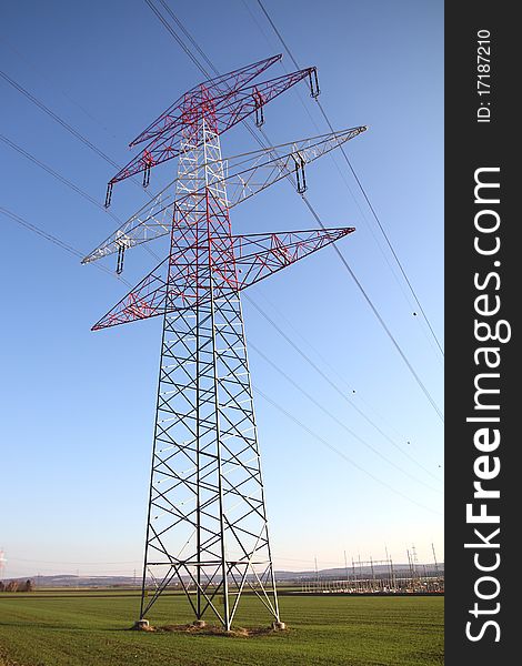 A pylon with power lines in a field