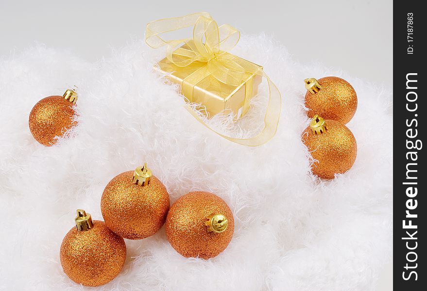 Christmas brightly golden spheres on the white fur