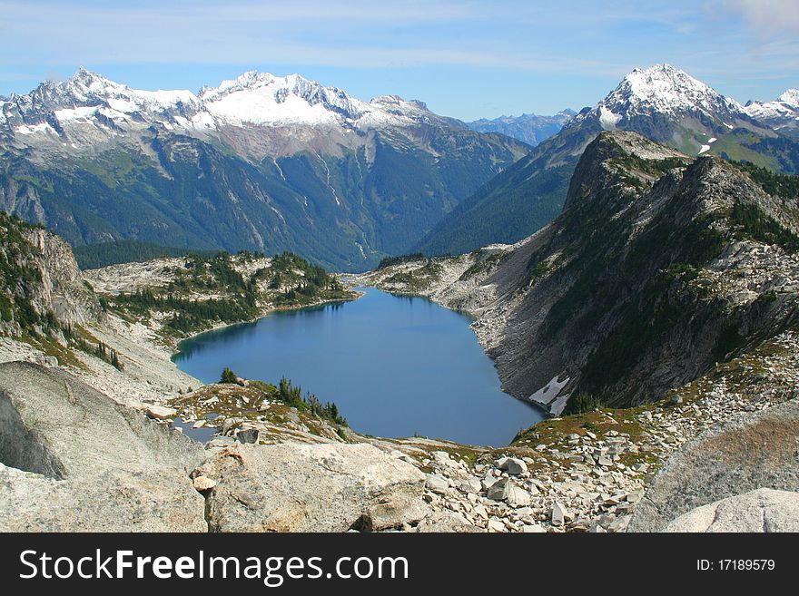High mountain lake surrounded by rugged, snow capped peaks in North Cascades National Park, Washington State. High mountain lake surrounded by rugged, snow capped peaks in North Cascades National Park, Washington State.
