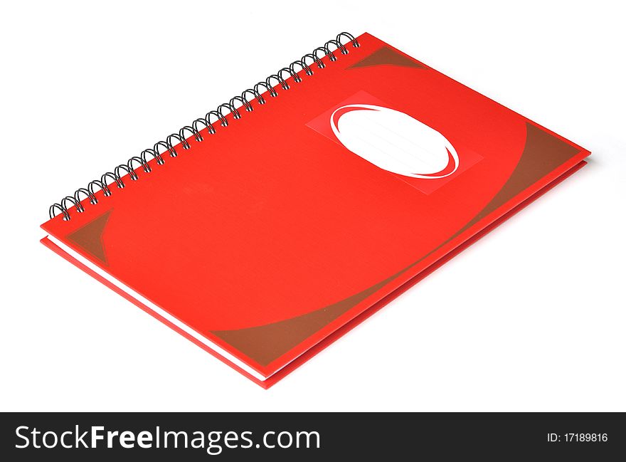 Red rectangular notebook with name label on cover.