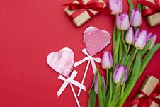 Pink Or Purple Tulip Flowers, Heart Shaped Chocolate And Gift Boxes On Red Background. Top View With Copy Space Stock Photography