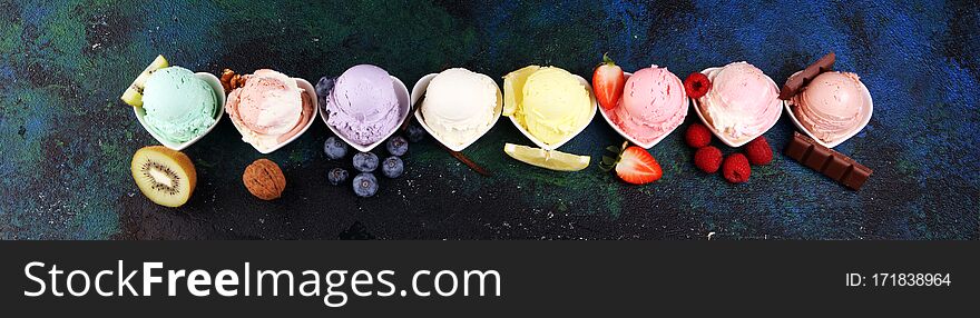 Various of ice cream flavor with fresh blueberry, strawberry, kiwi, lemon, vanilla setup on rustic background . Summer and Sweet ice cream