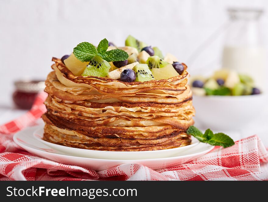 Thin crepe pancakes with fruits and berries. Crepe week.