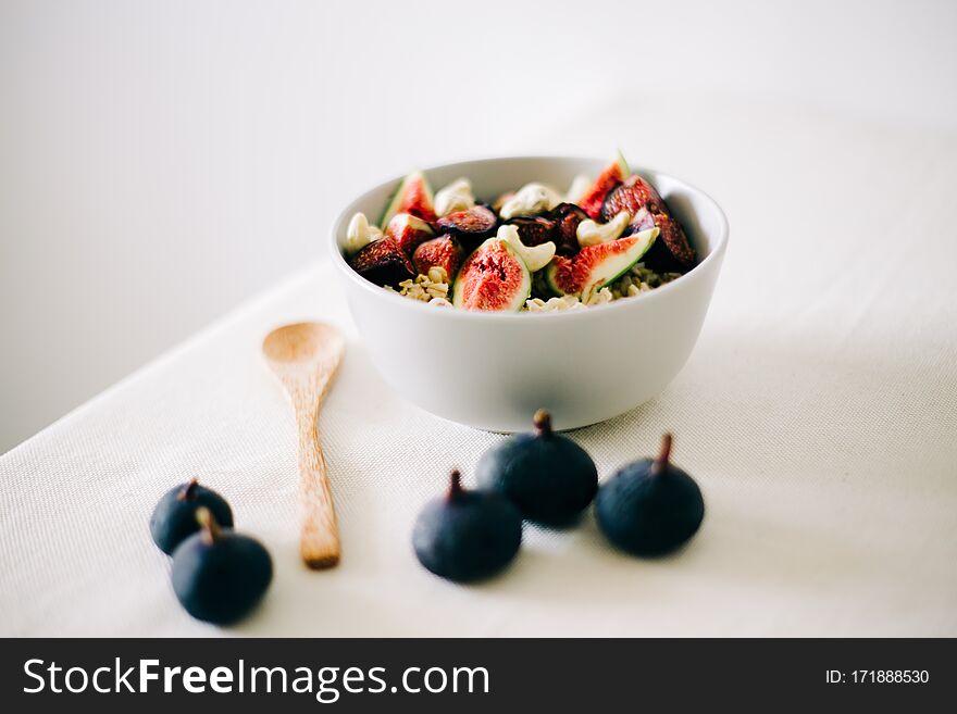 Healthy Breakfast oatmeal with figs and cashews on a white table. vegan food Healthy eating