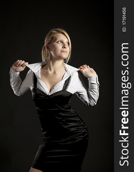 The business woman corrects a blouse on a black background. The business woman corrects a blouse on a black background