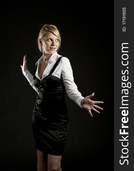 The business woman poses on a black background