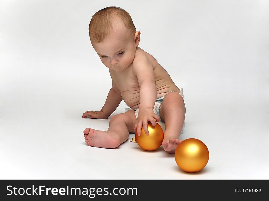 Baby playing with the Christmas glass ball on the white background. Baby playing with the Christmas glass ball on the white background