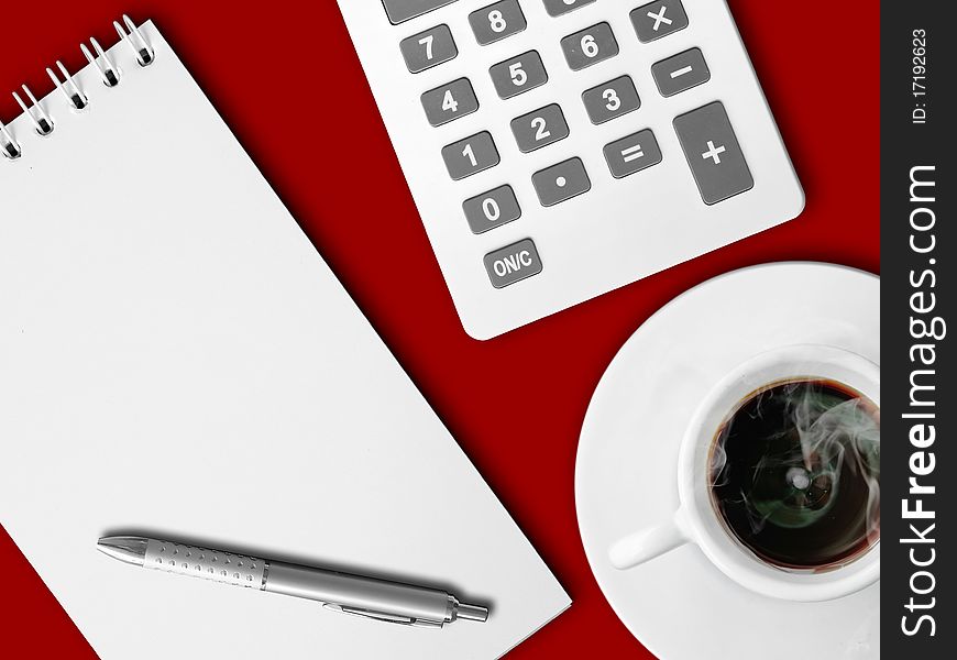 White calculator and white note paper with pen and white cup of hot coffee on red table. White calculator and white note paper with pen and white cup of hot coffee on red table