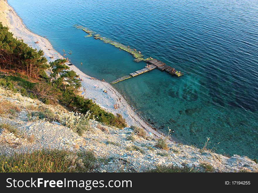 The top view on a wild beach and the azure sea