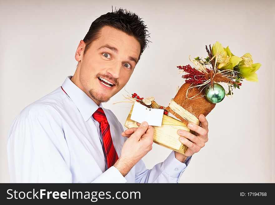 Young man in shirt and red tie hold Christmas gift and he is surprised. Young man in shirt and red tie hold Christmas gift and he is surprised