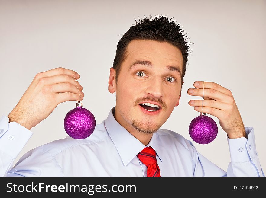 Happy young man in shirt and red tie shows violet Christmas Ornament. Happy young man in shirt and red tie shows violet Christmas Ornament
