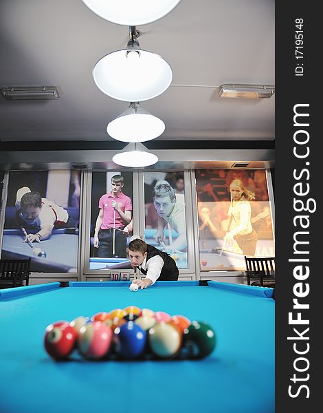 Young pro billiard player finding best solution and right angle at billard or snooker pool sport  game. Young pro billiard player finding best solution and right angle at billard or snooker pool sport  game