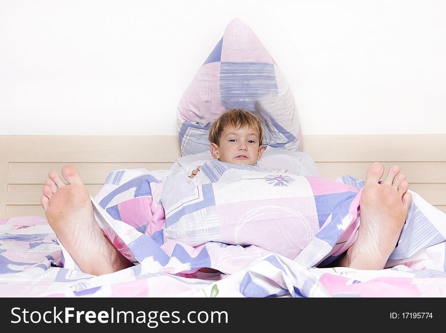 Child and parent's feet looking out from under blanket