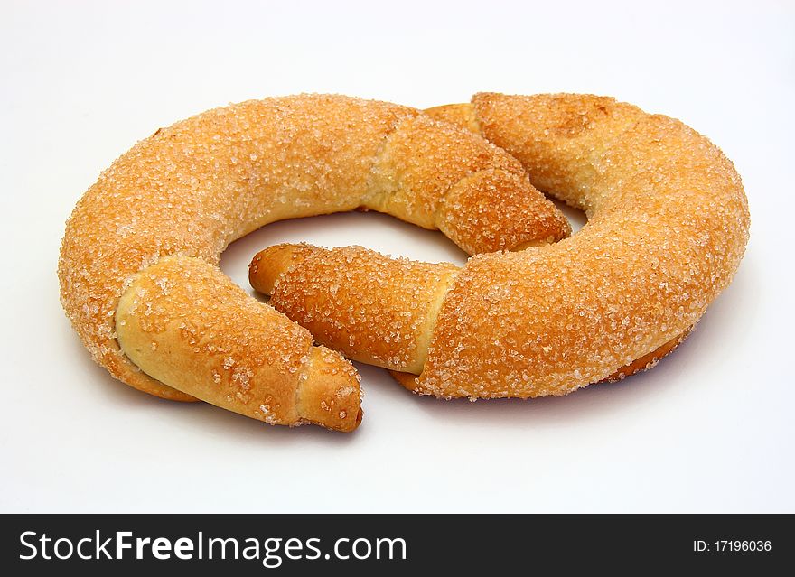 Fresh croissants are strewed by sugar on a white background