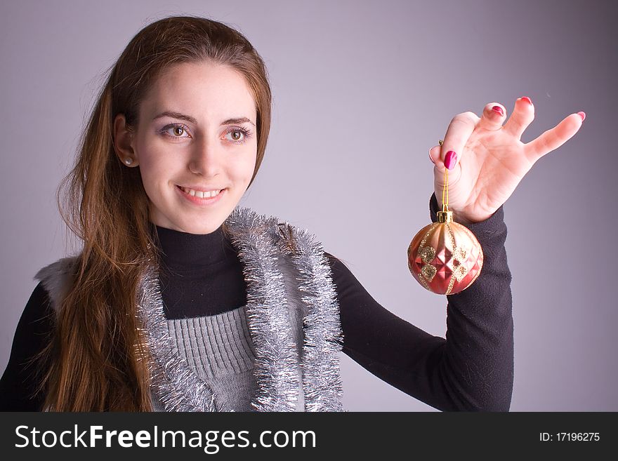 Beautiful girl smiling and holding Christmas decorations in her hand