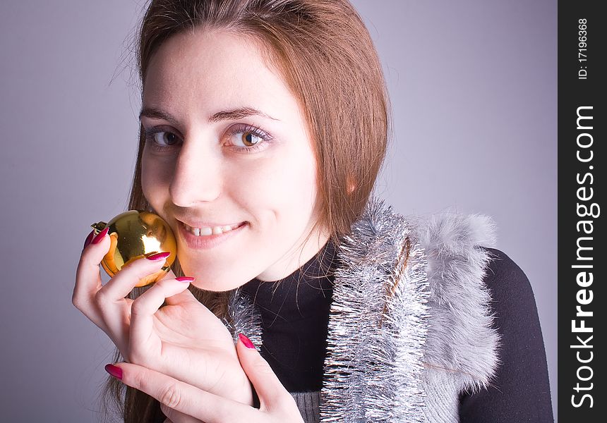 Beautiful girl smiling and holding Christmas decorations in her hand