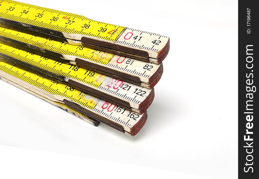 Detail of a yellow and white colored yardstick over white background. Detail of a yellow and white colored yardstick over white background