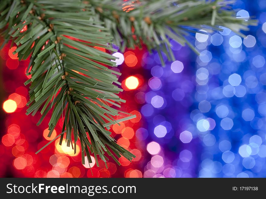 Christmas theme. Motley-colored background with a Christmas tree branch.
