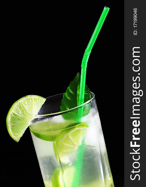 Mojito cocktail with fresh limes on a black background