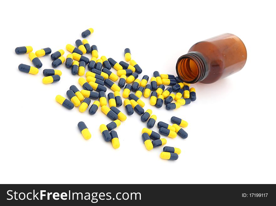 Open pill bottle with capsules spilling out of it isolated on white. Open pill bottle with capsules spilling out of it isolated on white