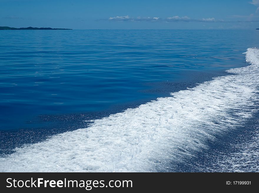 WS: Calm blue sea in tropical Fiji, with a frothy white speedboat wash (wake) filling LR third. WS: Calm blue sea in tropical Fiji, with a frothy white speedboat wash (wake) filling LR third