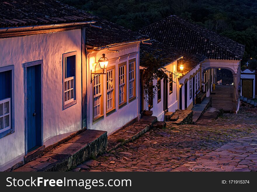 Night View Of An Old Cobbled Street And Its Colonial-style Houses Lit By Lanterns