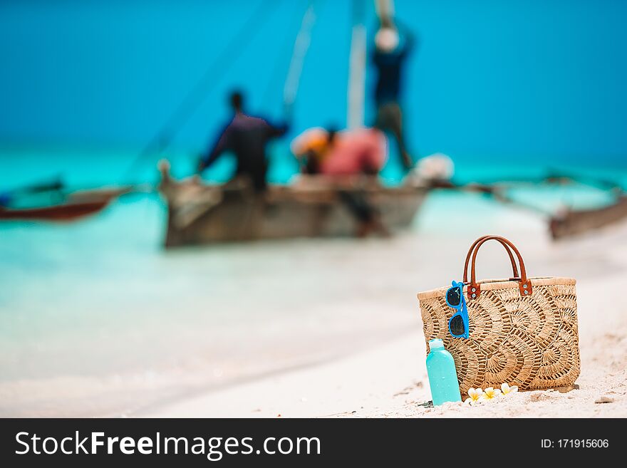 Beach accessories - bag, straw hat, sunglasses on white beach. Beach accessories - bag, straw hat, sunglasses on white beach