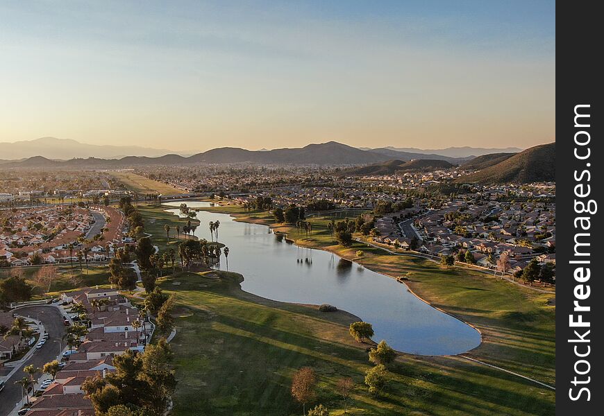 Aerial view of golf course surrounded by town houses and luxury villas during sunset time, Temecula
