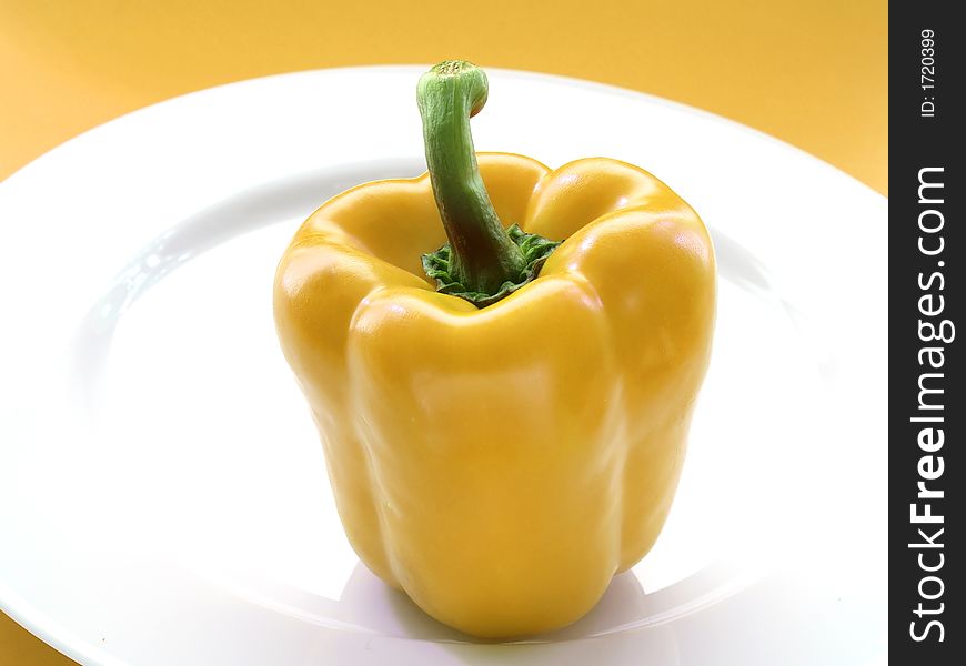 Yellow pepper on a white ceramic plate