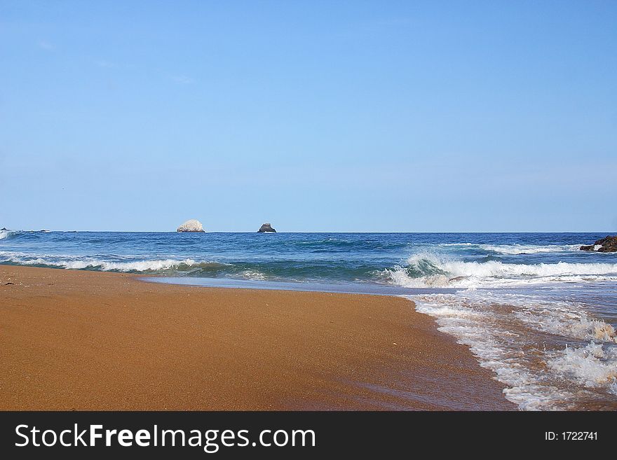 Partial view of a wave and a small island in the bay of San Agustinillo in the southern state of Oaxaca in  Mexico, Latin America. Partial view of a wave and a small island in the bay of San Agustinillo in the southern state of Oaxaca in  Mexico, Latin America