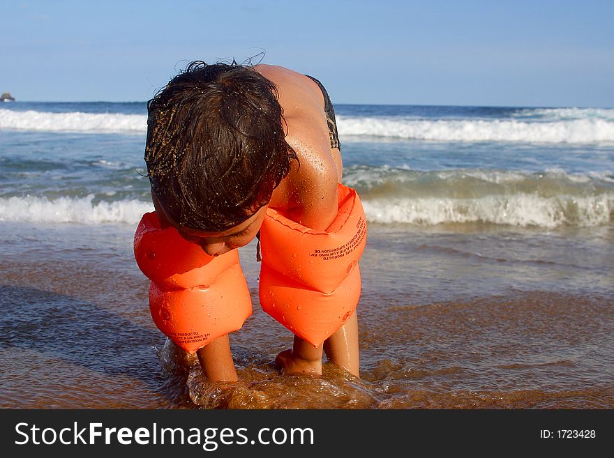 Boy playing sand at the bay of San Agustinillo in the southern state of Oaxaca in Mexico, Latinamerica. Boy playing sand at the bay of San Agustinillo in the southern state of Oaxaca in Mexico, Latinamerica